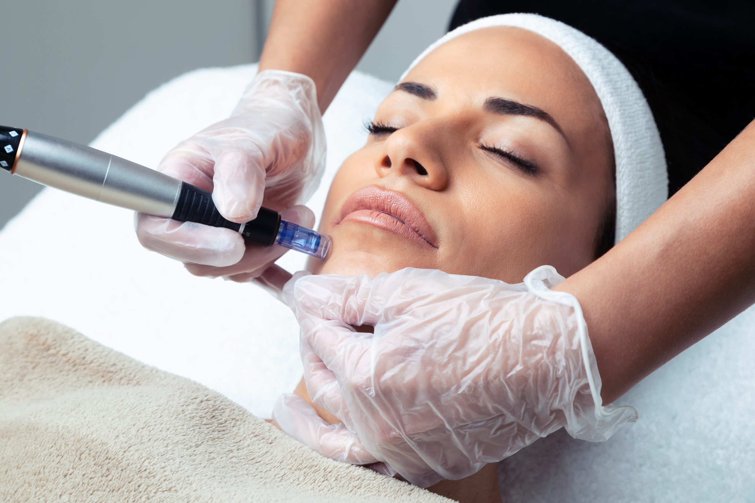 Shot of Cosmetologist Performing Mesotherapy Injection with Dermapen on Face for Rejuvenation in the Spa center.