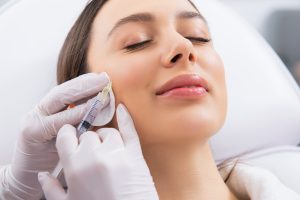 Woman receiving dermal filler injection in the cheek area